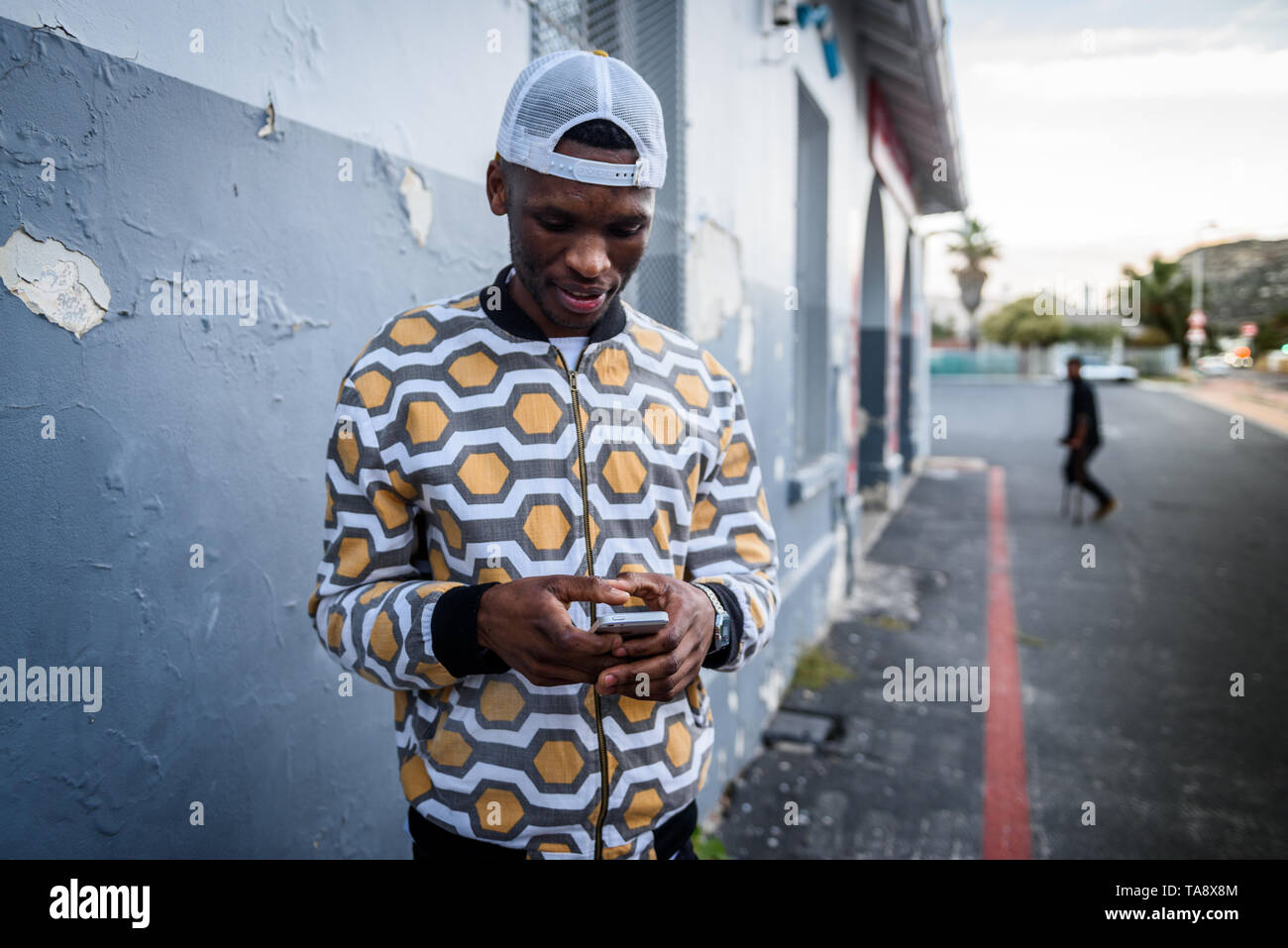 Ein Mann auf sein Handy im St James Bahnhof auf Südafrikas Kap Halbinsel, in der Nähe von Kapstadt Stockfoto