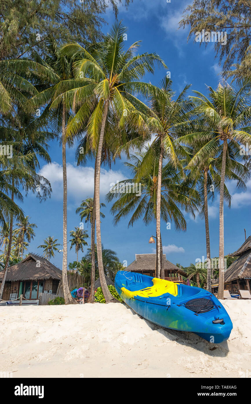 Sommer Urlaub mit Aktivität am tropischen Strand Konzept. Farbenfrohe Kajak Boot auf weißen Sandstrand mit Kokosnuss Palmen im Hintergrund. Stockfoto