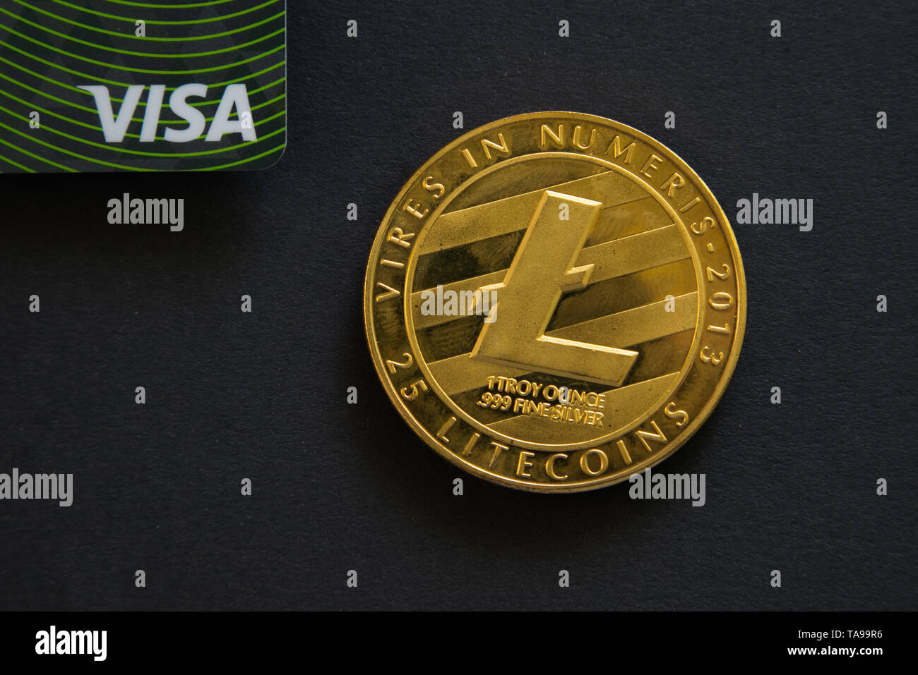 Prag, tschechische Republik - Mai, 2019: Goldene Litecoin neben Visa Kreditkarte auf schwarzem Hintergrund. Digitale Währung, block Kette Markt Stockfoto