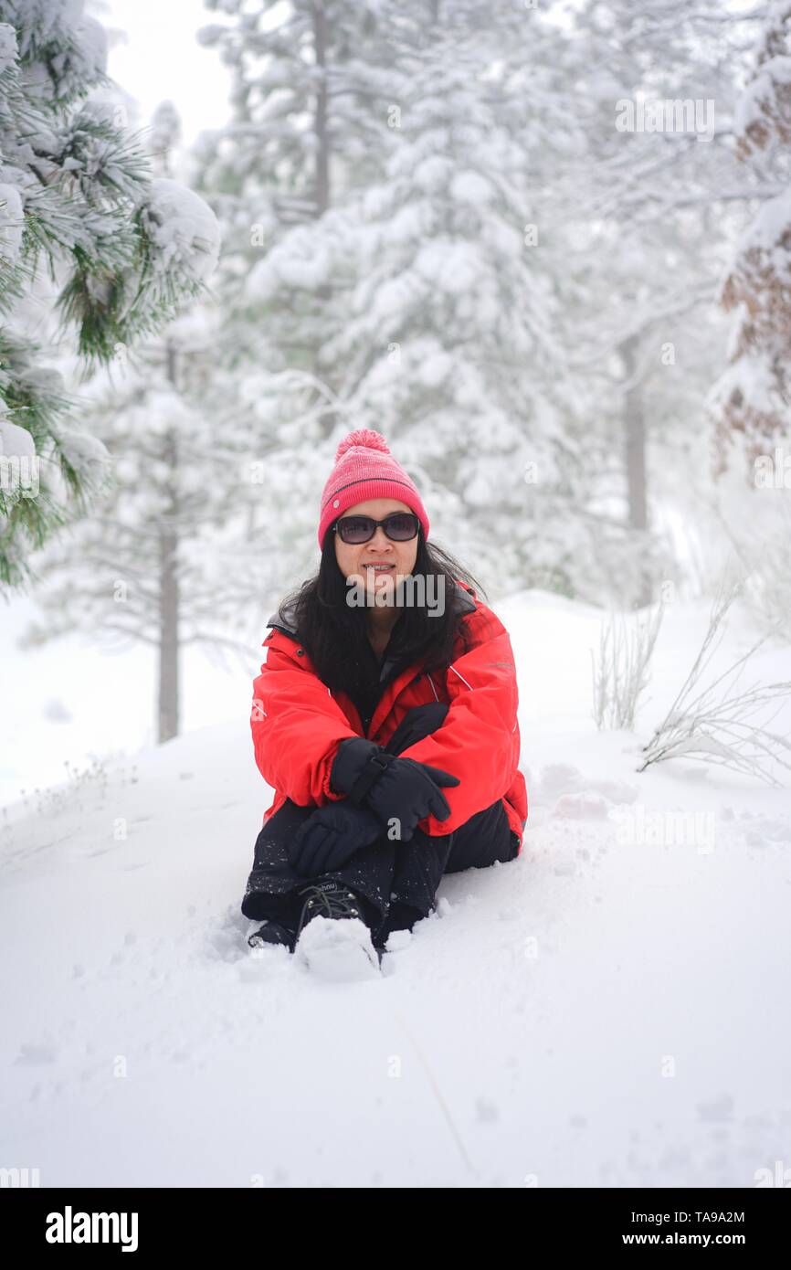 Eine Frau entspannende und Sitzen im Schnee bei Big Bear Mountain. Stockfoto