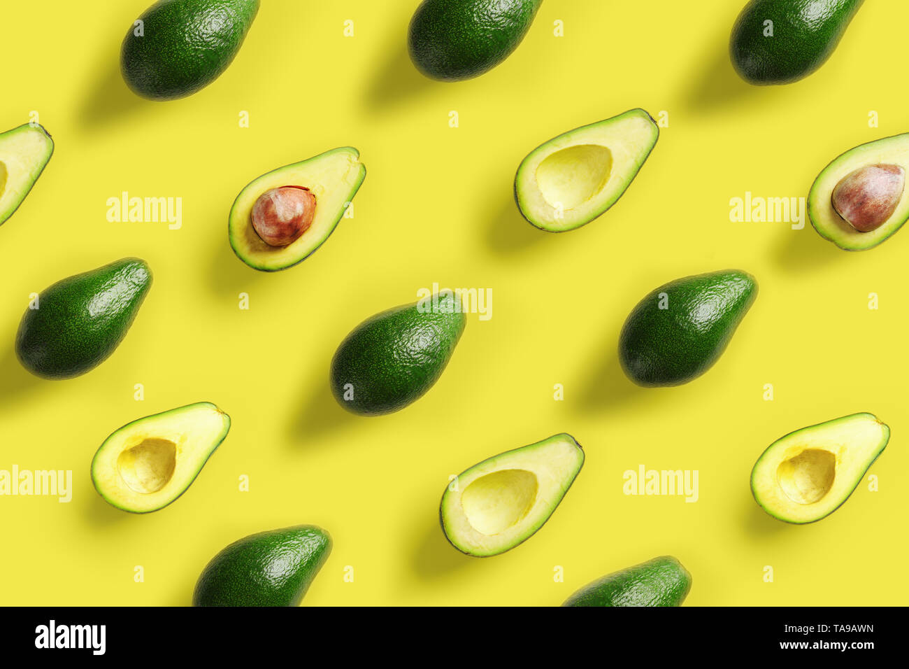 Avocado Muster auf gelben Hintergrund. Pop Art Design, kreative Sommer essen Konzept. Grüne Avocados, minimale flach Stil. Ansicht von oben Stockfoto