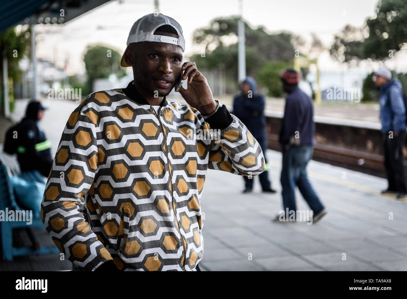 Ein Mann auf sein Handy im St James Bahnhof auf Südafrikas Kap Halbinsel, in der Nähe von Kapstadt Stockfoto