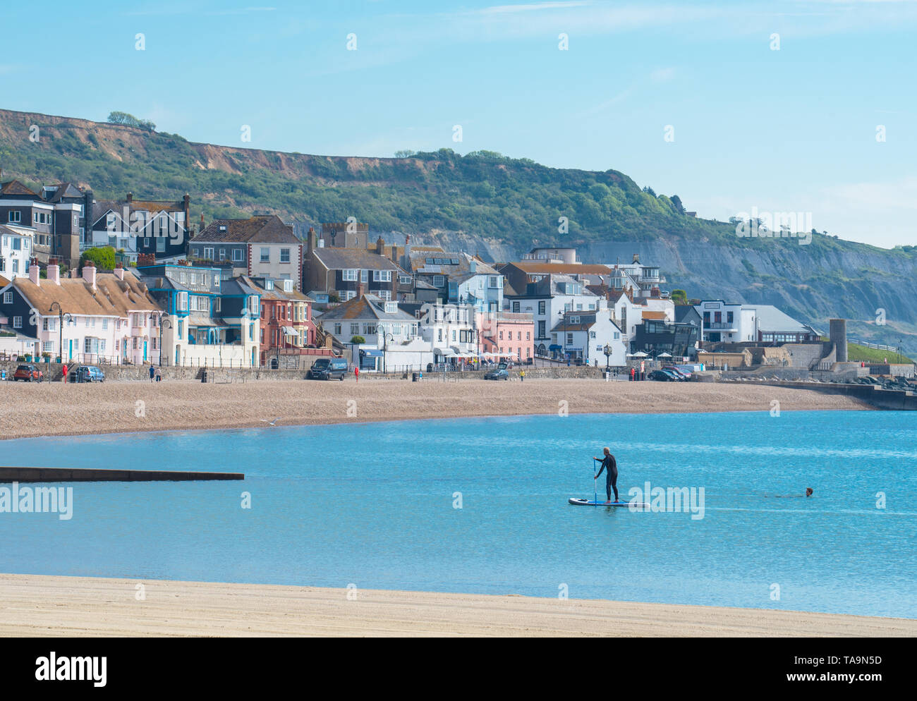 Lyme Regis, Dorset, Großbritannien. 23. Mai 2019. UK Wetter: Ein herrlicher Morgen am malerischen Strand in der Küstenstadt Lyme Regis. Das beliebte Resort liegt ruhig und still heute vor der bevorstehenden May Bank Holiday. Ein einsamer Paddel boarder nutzt die Vorteile der friedlichen Bedingungen. Massen sind in Scharen zum beliebten Strand nächste Woche erwartet in der lauen Wetter, die über der Südküste von England Prognose wurde zu sonnen. Credit: Celia McMahon/Alamy Leben Nachrichten. Stockfoto