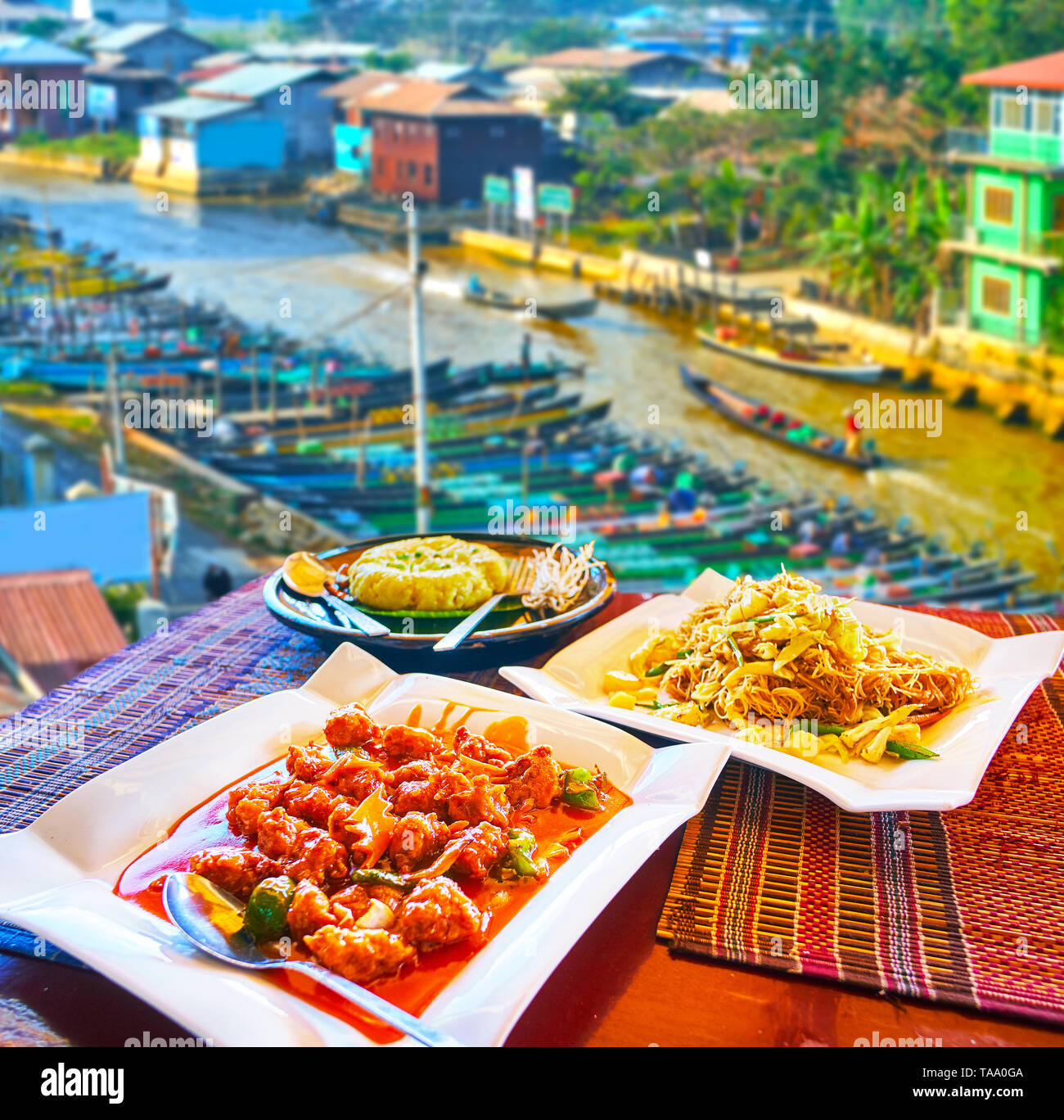 Besten Cafés von Nyaungshwe resort Terrassen bieten in den oberen Etagen mit Blick auf den kanal Inle See, Kanus und die leckeren Gerichte der burmesischen Küche - Schwein s Stockfoto