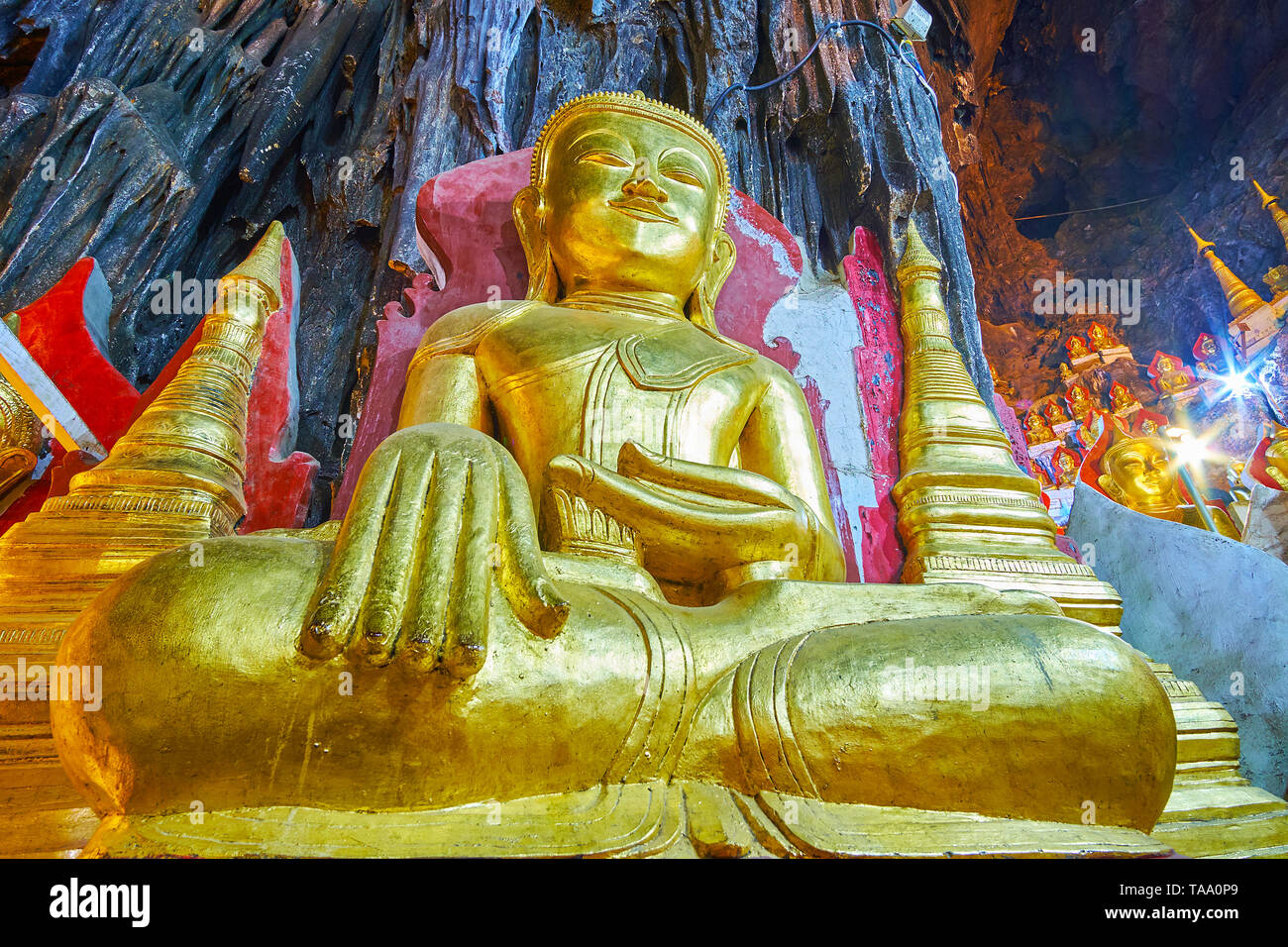 PINDAYA, MYANMAR - 19. FEBRUAR 2018: Die goldene Statue von Buddha in der Erde Zeugnis" (bei Berühren der Erde) Geste im großen Saal des alten Pindaya Cave, auf Stockfoto