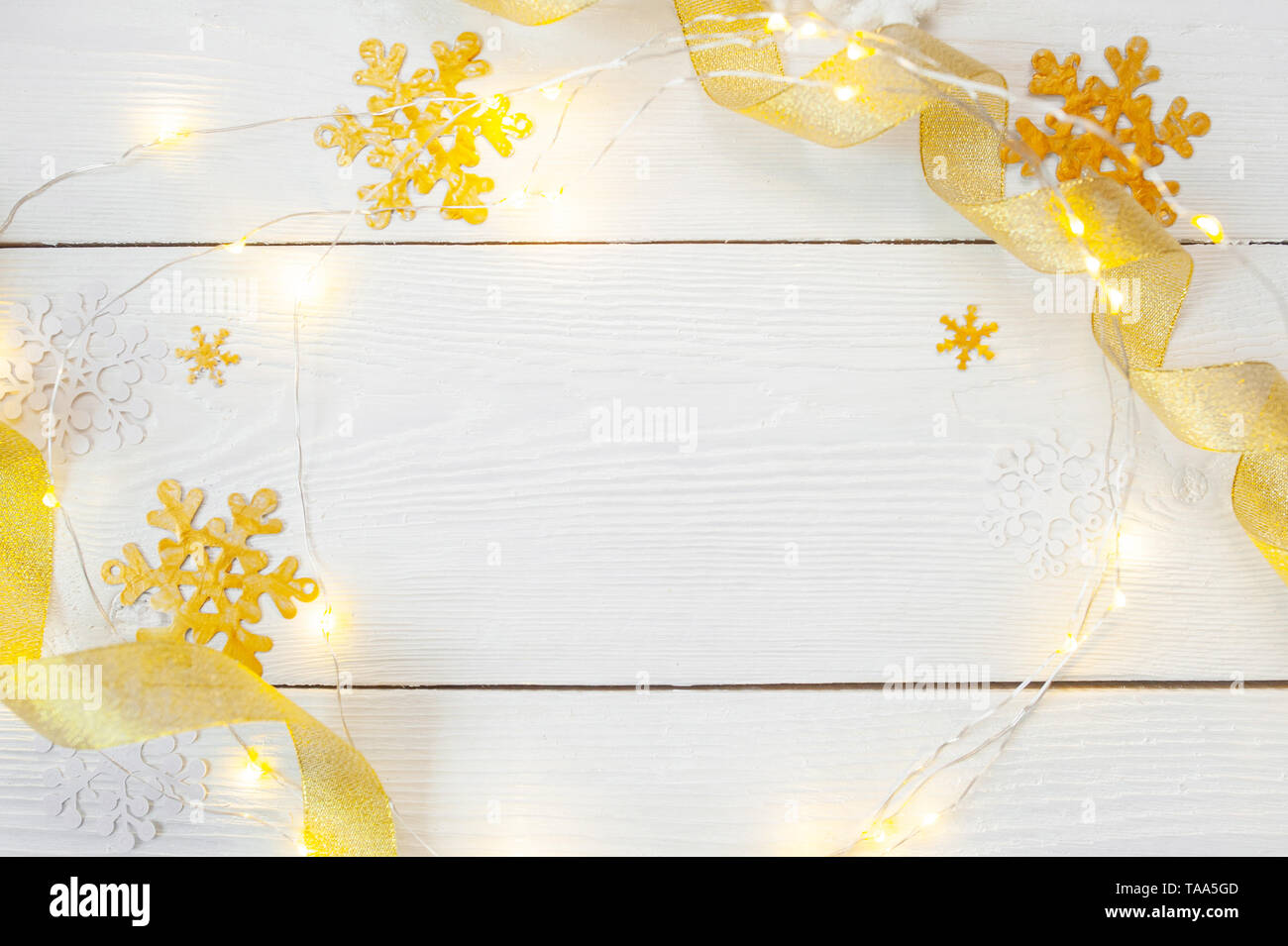 Weihnachten Hintergrund für Grußkarte mit Platz für Text. Weihnachten goldene Spielzeug und Band auf Holzhintergrund. Flach liegend, Draufsicht Fotomockup Stockfoto