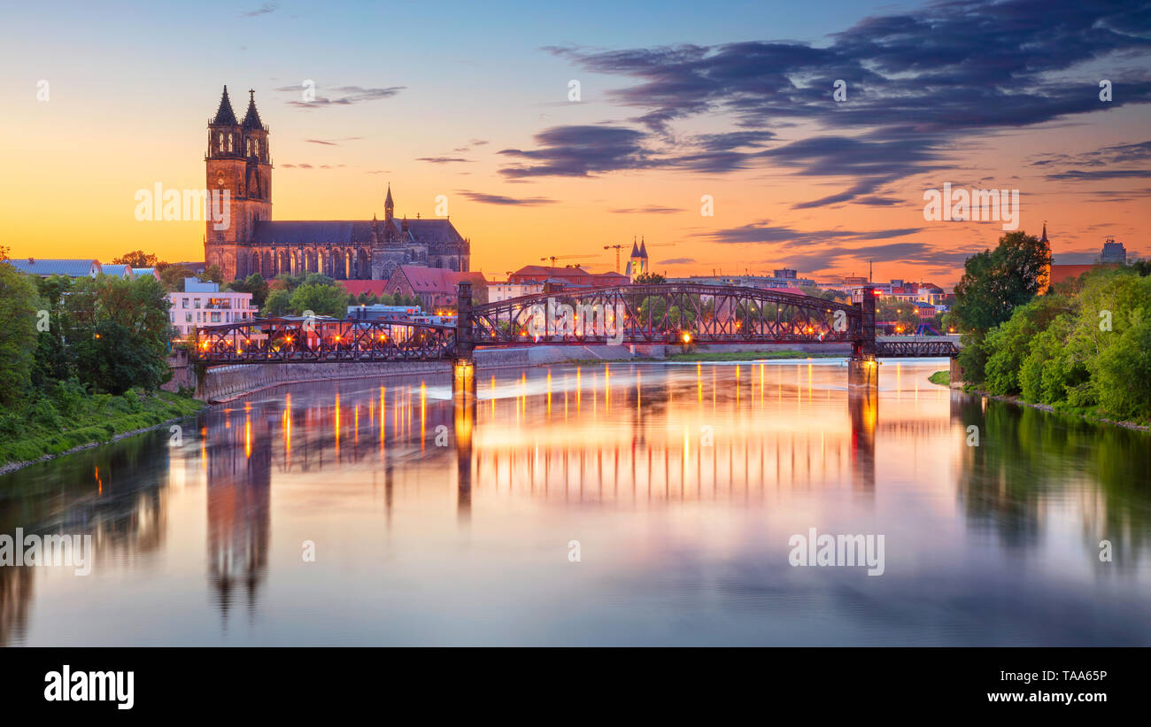 Magdeburg, Deutschland. Stadtbild Bild von Magdeburg, Deutschland mit Reflexion der Stadt in der Elbe, während des Sonnenuntergangs. Stockfoto