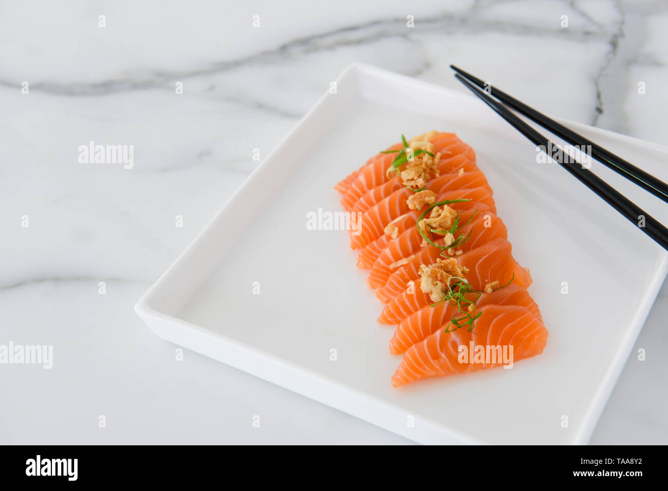 Frisch geschnittenen Lachs sashimi auf weiße Platte mit Stäbchen, flach Stockfoto