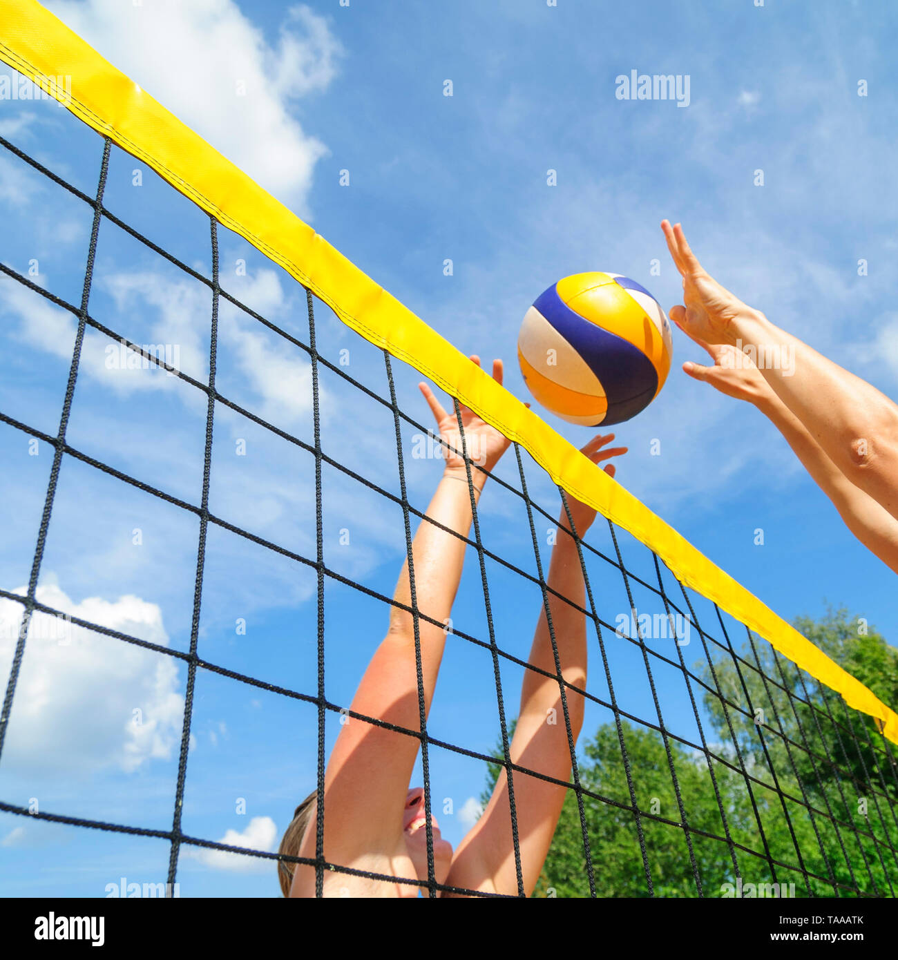 Konkurrierende Spiel auf Beachvolleyball Court am Netz Stockfoto