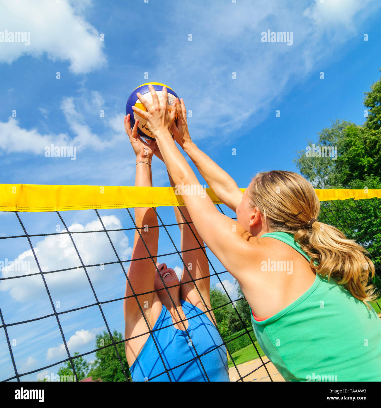 Konkurrierende Spiel auf Beachvolleyball Court am Netz Stockfoto