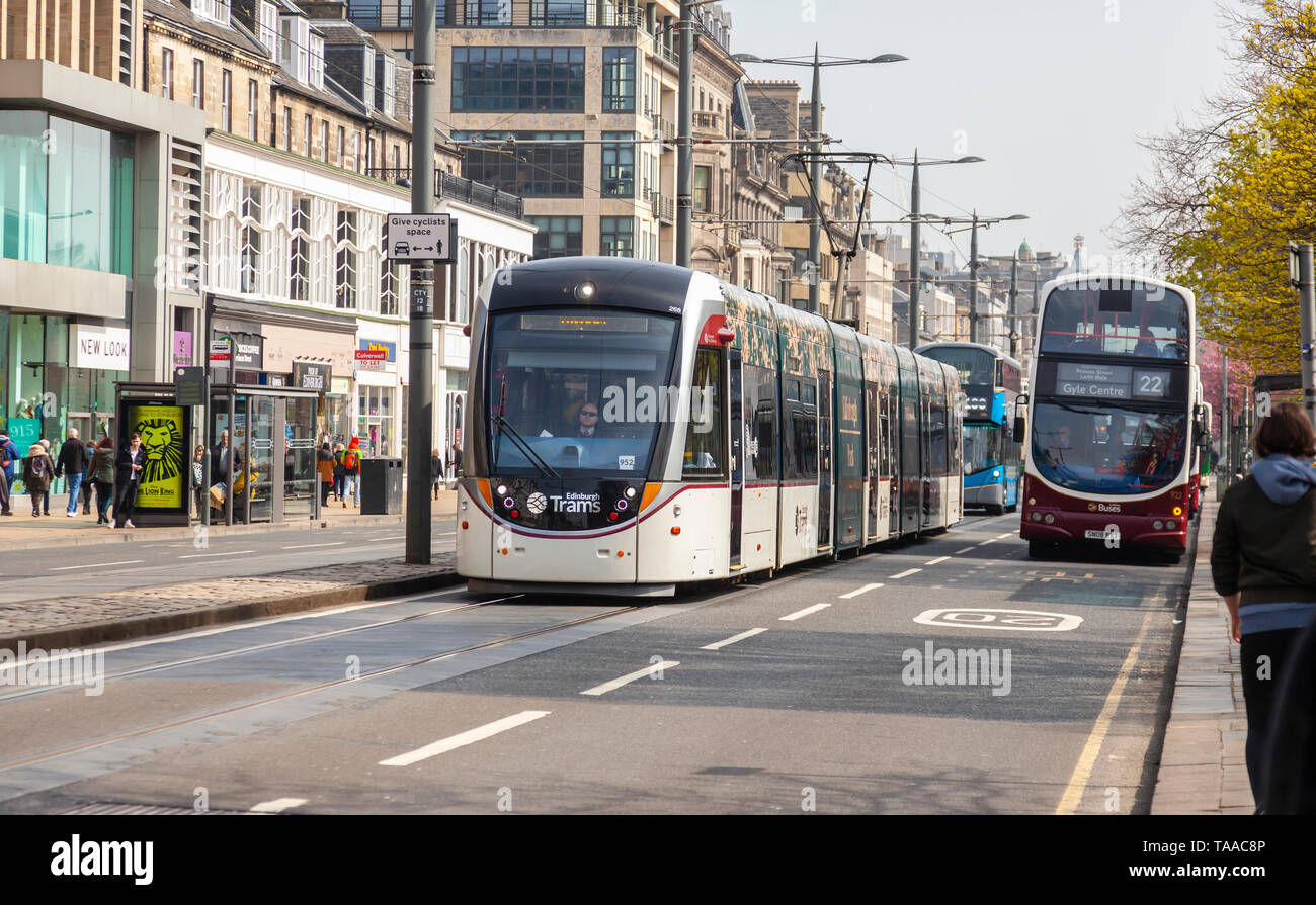 Öffentliche Verkehrsmittel an der Princes Street, Edinburgh, Schottland, mit einem Bus in einem Bus Lane, einer Straßenbahn auf die Straßenbahnschienen. Mehrere Busse sind hinter der Straßenbahn Stockfoto