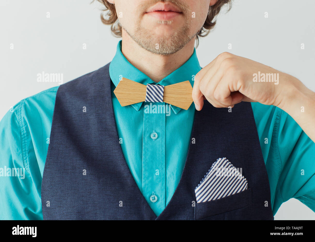 Mode junger Mann im blauen Hemd und Anzug korrigiert seine hölzernen bowtie Stockfoto