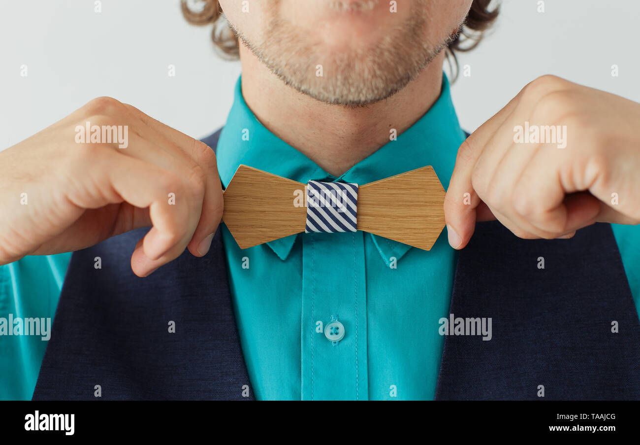 Junger Mann im blauen Hemd und Anzug korrigiert seine hölzernen bowtie Stockfoto