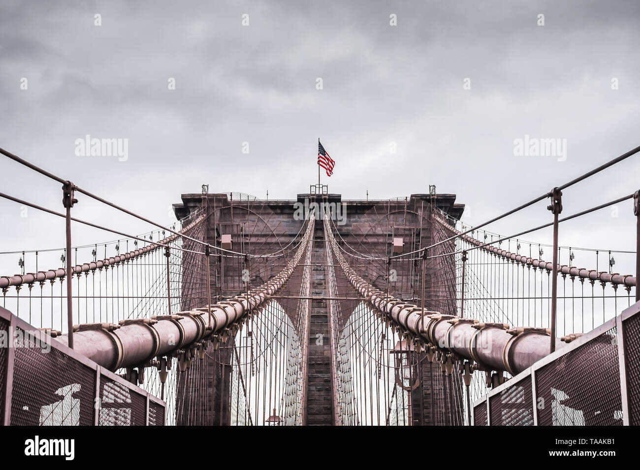 Riesige dramatischen Landschaft der Architektur der berühmten Brooklyn Bridge In New York City im Rahmen einer kontrastierenden stürmischen Himmel Stockfoto
