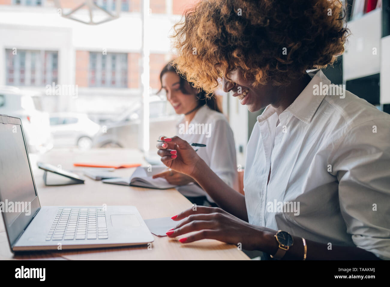 Zwei junge Multirassischen Frauen schreiben und an einem Projekt zusammen zu arbeiten - Freier, einfallsreich, Kreativität Stockfoto