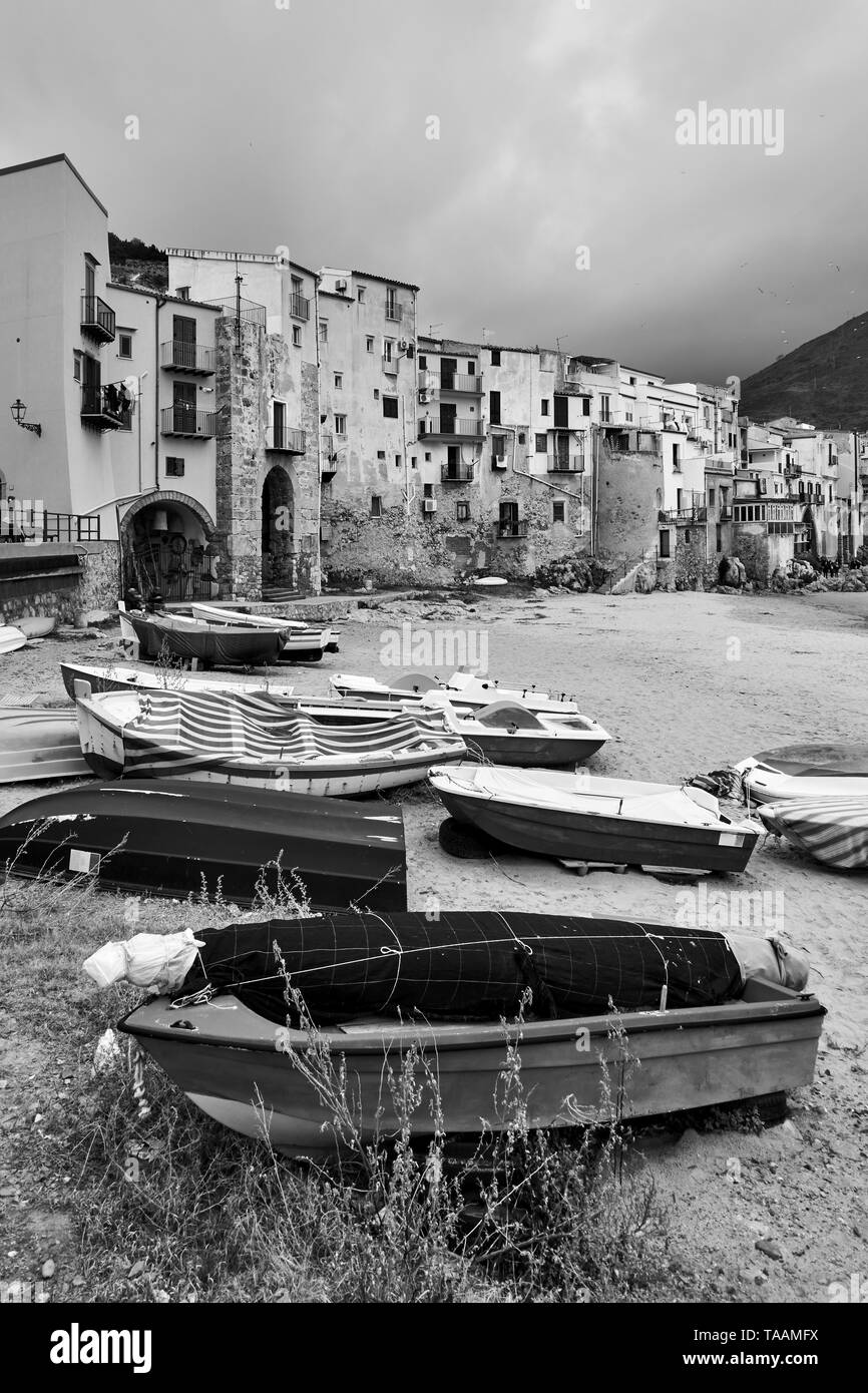 Boote auf den Strand und die alten Häuser am Meer in Cefalu, Sizilien, Italien - Schwarze und Weiße Landschaft Stockfoto