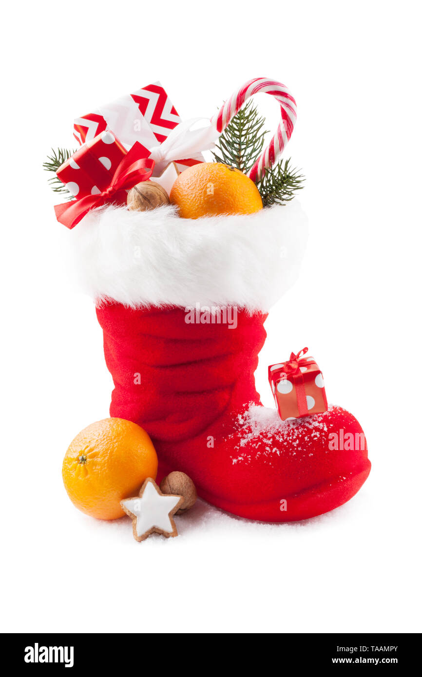 Santa Stiefel mit Süßigkeiten und Geschenke auf weißem Hintergrund Stockfoto