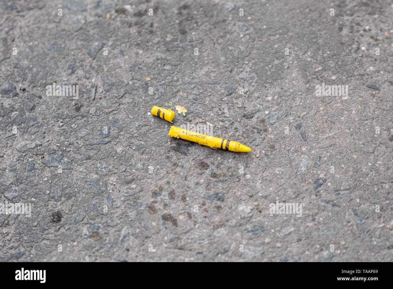 Unterbrochener gelber Kreide liegen auf einem schmutzig grauen Beton Straße Stockfoto