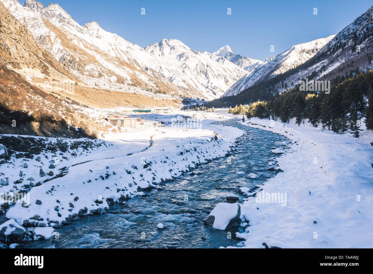 Die Kälte und ruhige Baspa Fluss fließt in Richtung Sangla Valley über die schneebedeckten Berge und Chitkul, Himachal Pradesh. Stockfoto