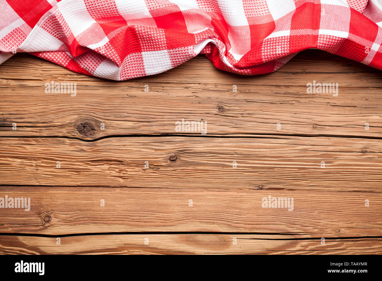 Karierte Tischdecke auf einem alten rustikalen Holzmöbeln Hintergrund Stockfoto