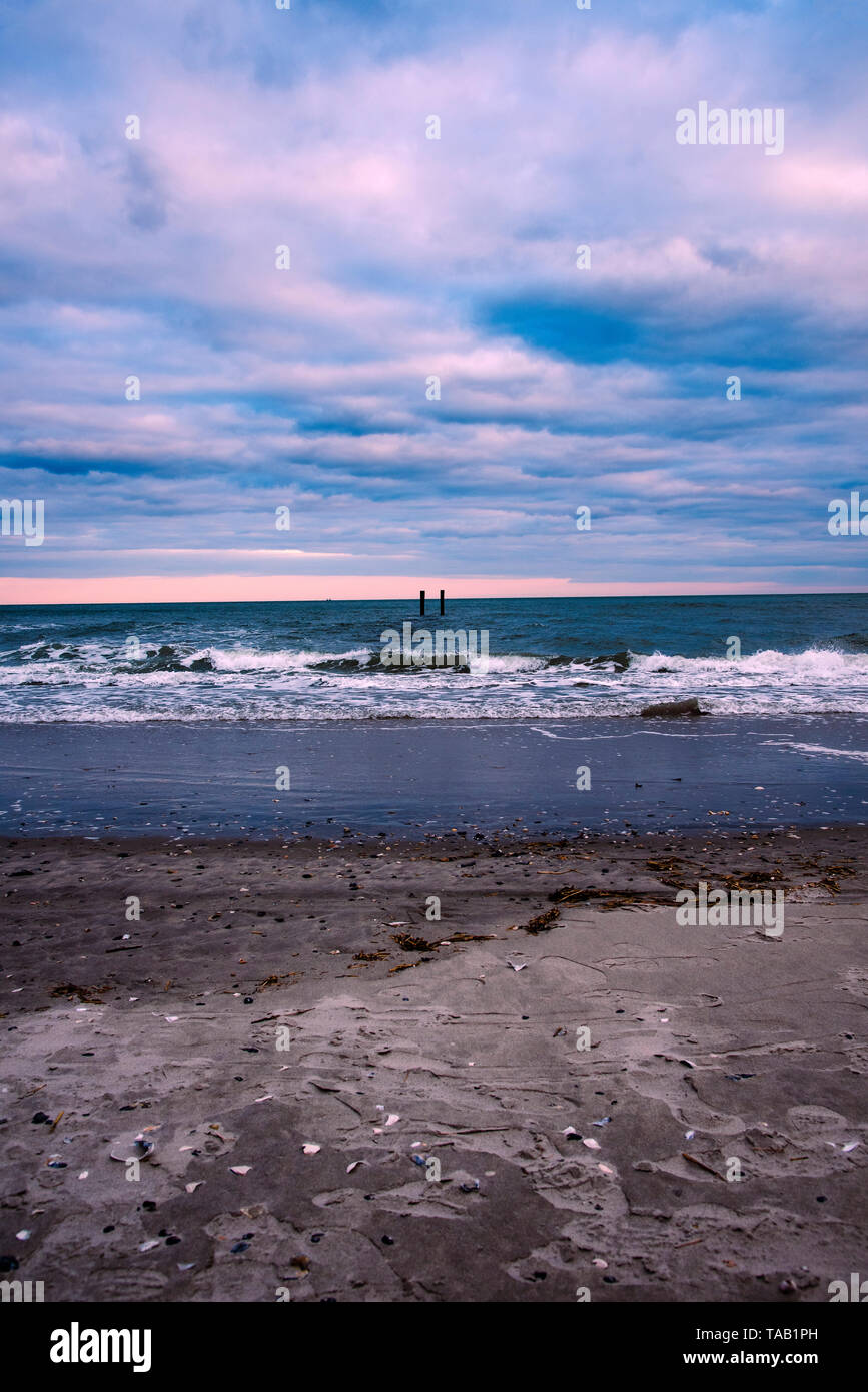 Wellen hinterlassen winzige Muscheln auf Atlantic City Beach. Stockfoto