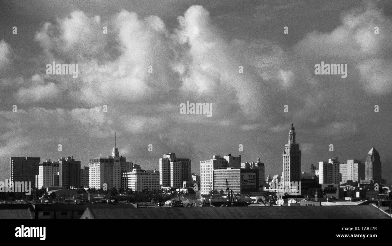 AJAXNETPHOTO. SEPTEMBER, 1963. MIAMI, Fla, USA. -Stadtzentrum von Miami - THUNDERY WOLKEN Gebäude über die Skyline der Stadt. Höchste Gebäude (Mitte, rechts.) ist Miami Dade County COLLEGE FREEDOM TOWER, JETZT (21. Jahrhundert) TEIL DES MUSEUM FÜR KUNST UND DESIGN. Foto: Jonathan Eastland/AJAX REF: M 1206311 1 2 Stockfoto