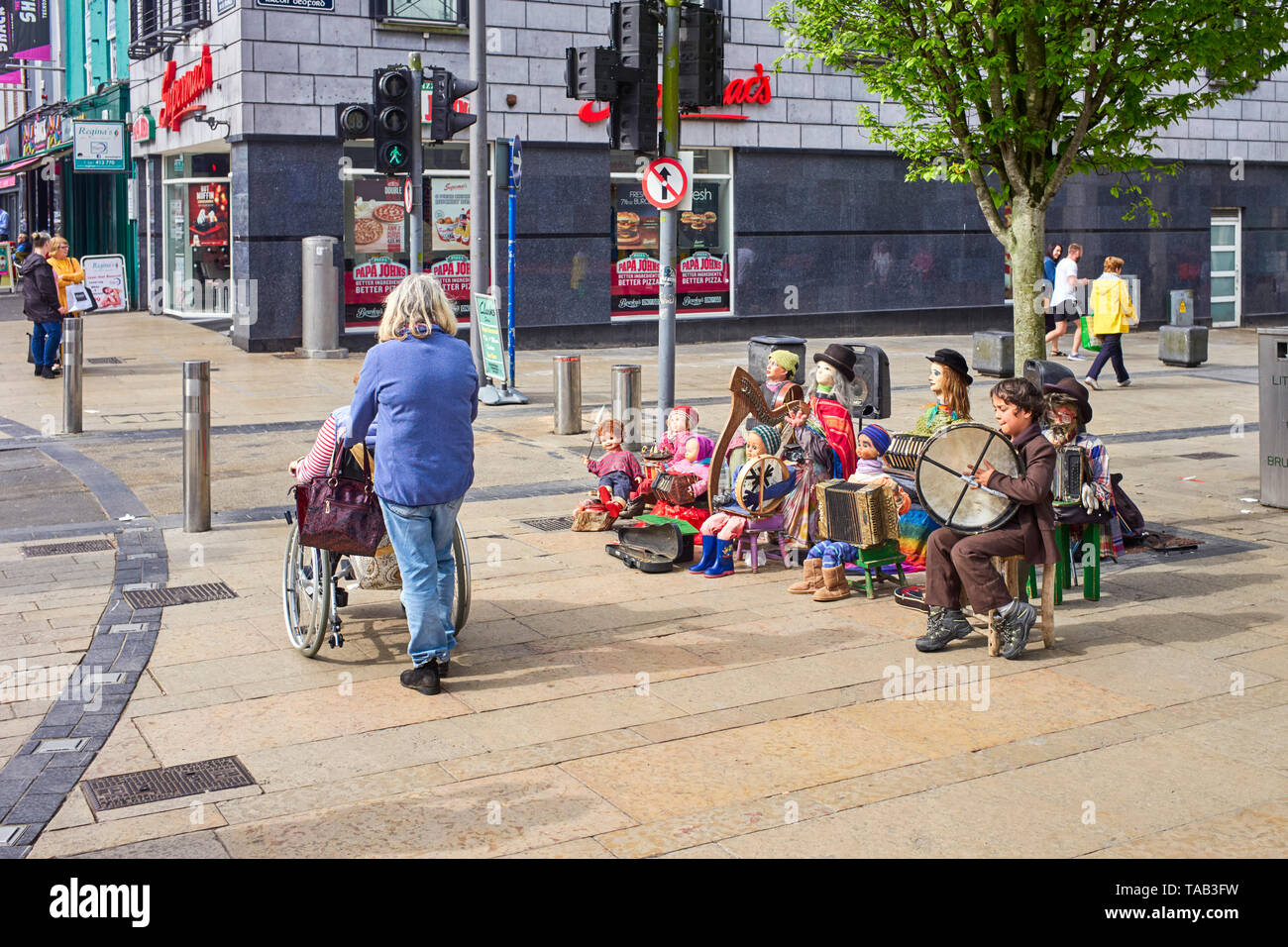 Ein kleiner Junge spielt zusammen mit Automaten in der O'Connell Street, Limerick, Irland, Stockfoto