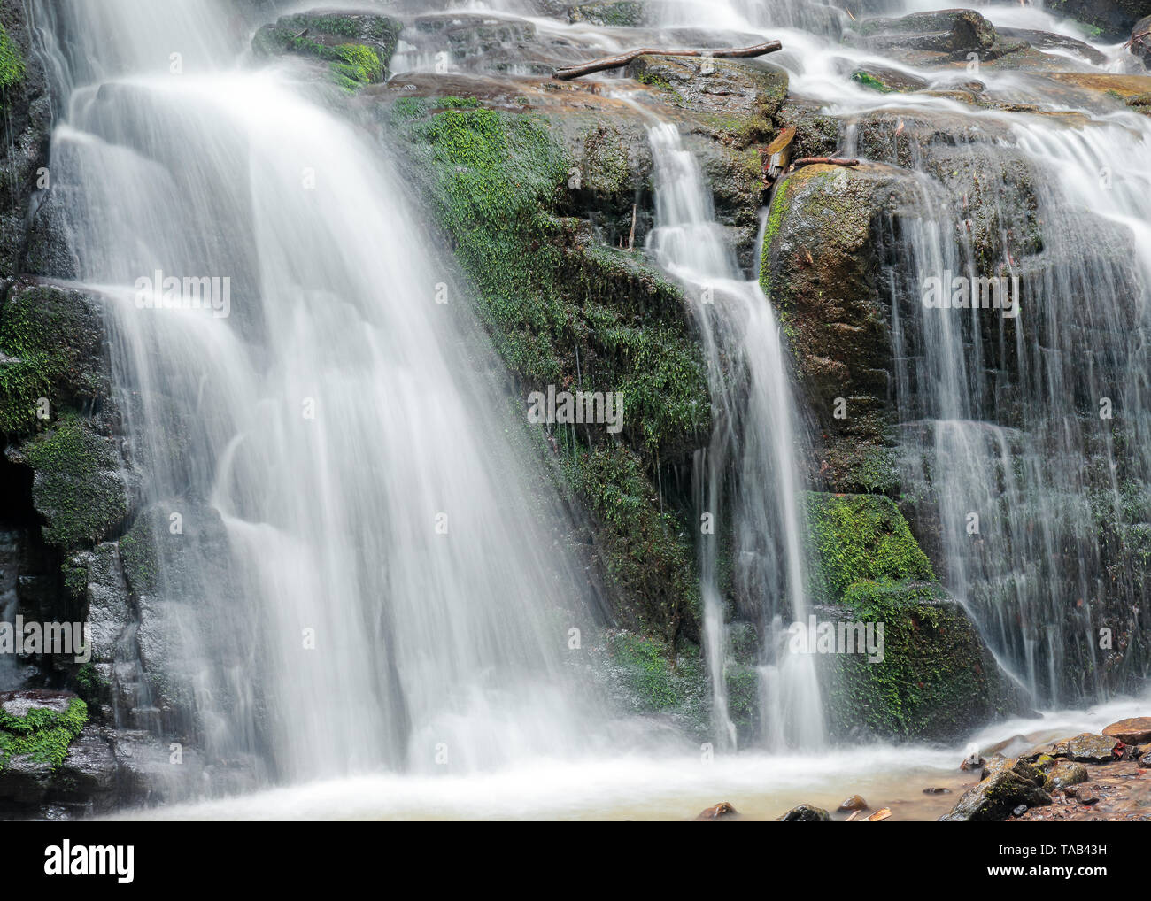 Nahaufnahme der Wasserfall Kaskade über die bemoosten Felsen. schönen ruhigen Natur Hintergrund. Frische und Energie des Wassers. Klare Umwelt und Ressourcen con Stockfoto
