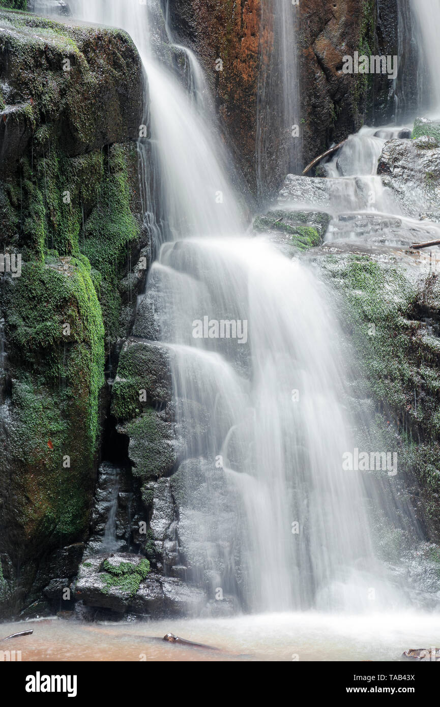 Nahaufnahme der Wasserfall Kaskade über die bemoosten Felsen. schönen ruhigen Natur Hintergrund. Frische und Energie des Wassers. Klare Umwelt und Ressourcen con Stockfoto