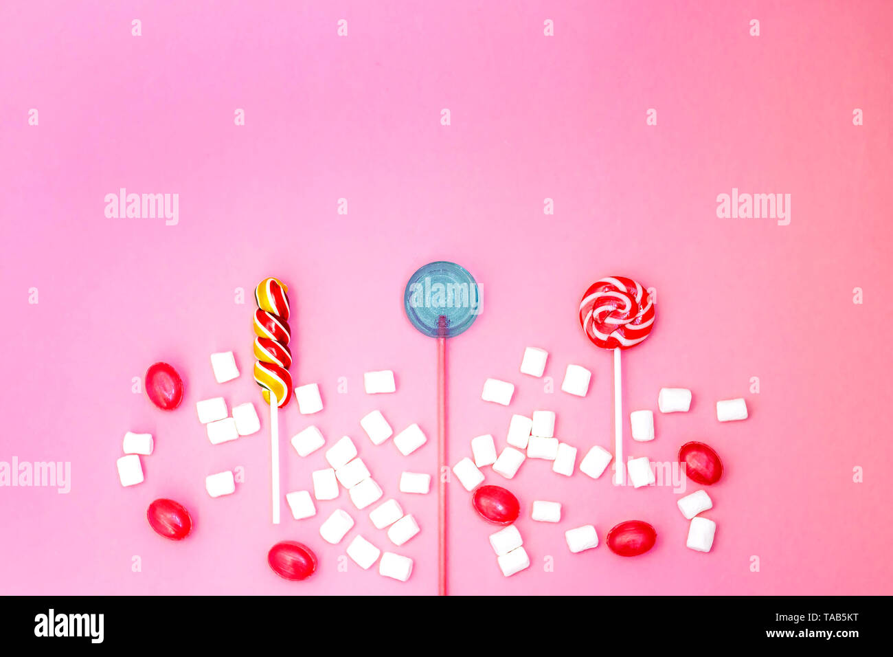 Flach Zusammensetzung mit leckeren Lutscher und Marshmallows und Platz für Text auf rosa Hintergrund Stockfoto