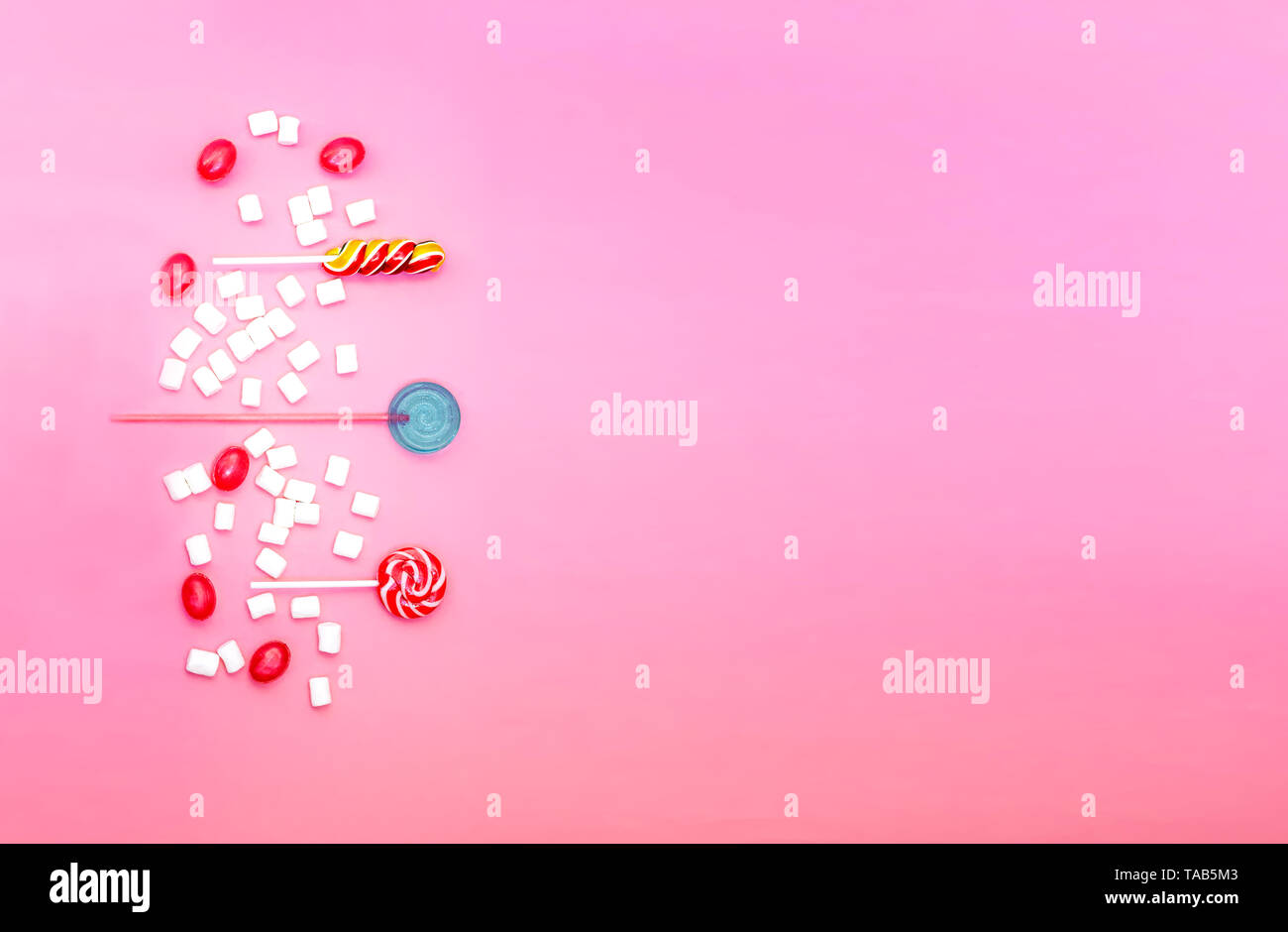 Flach Zusammensetzung mit leckeren Lutscher und Marshmallows und Platz für Text auf rosa Hintergrund Stockfoto