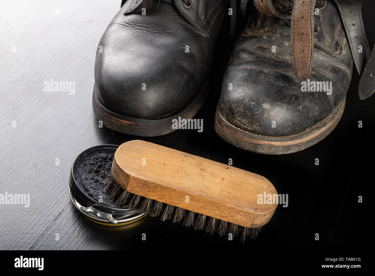 Schuhcreme, Bürste und Schwarze Militärstiefel. Polieren und Reinigen Schuhe  auf einem Schwarzen Tisch. Der dunkle Hintergrund Stockfotografie - Alamy