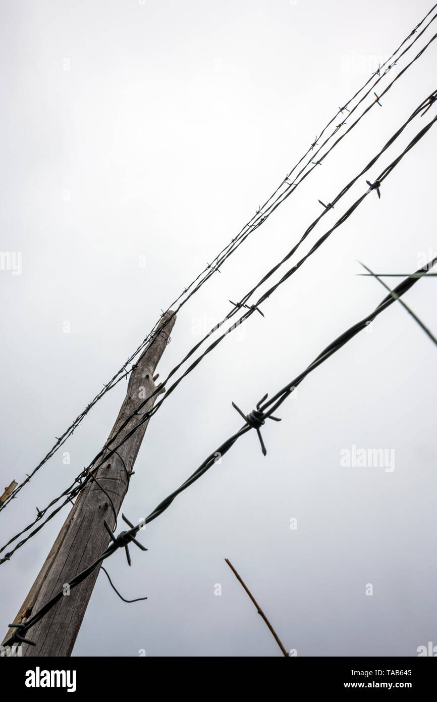 In der Nähe von Stacheldraht zaun & Holzzaun Post gegen bedeckt stürmischen Himmel; Ranch in Colorado, USA Stockfoto