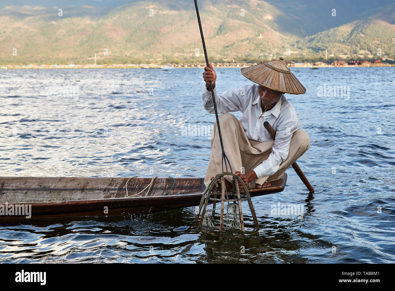 Traditionelle Fischer mit Net auf Bootsfahrt auf dem Inle See, Myanmar. Stockfoto