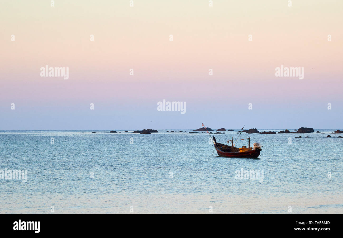 Kleines Fischerboot im Meer bei Sonnenaufgang in Ngapali, Myanmar in Südostasien. Stockfoto