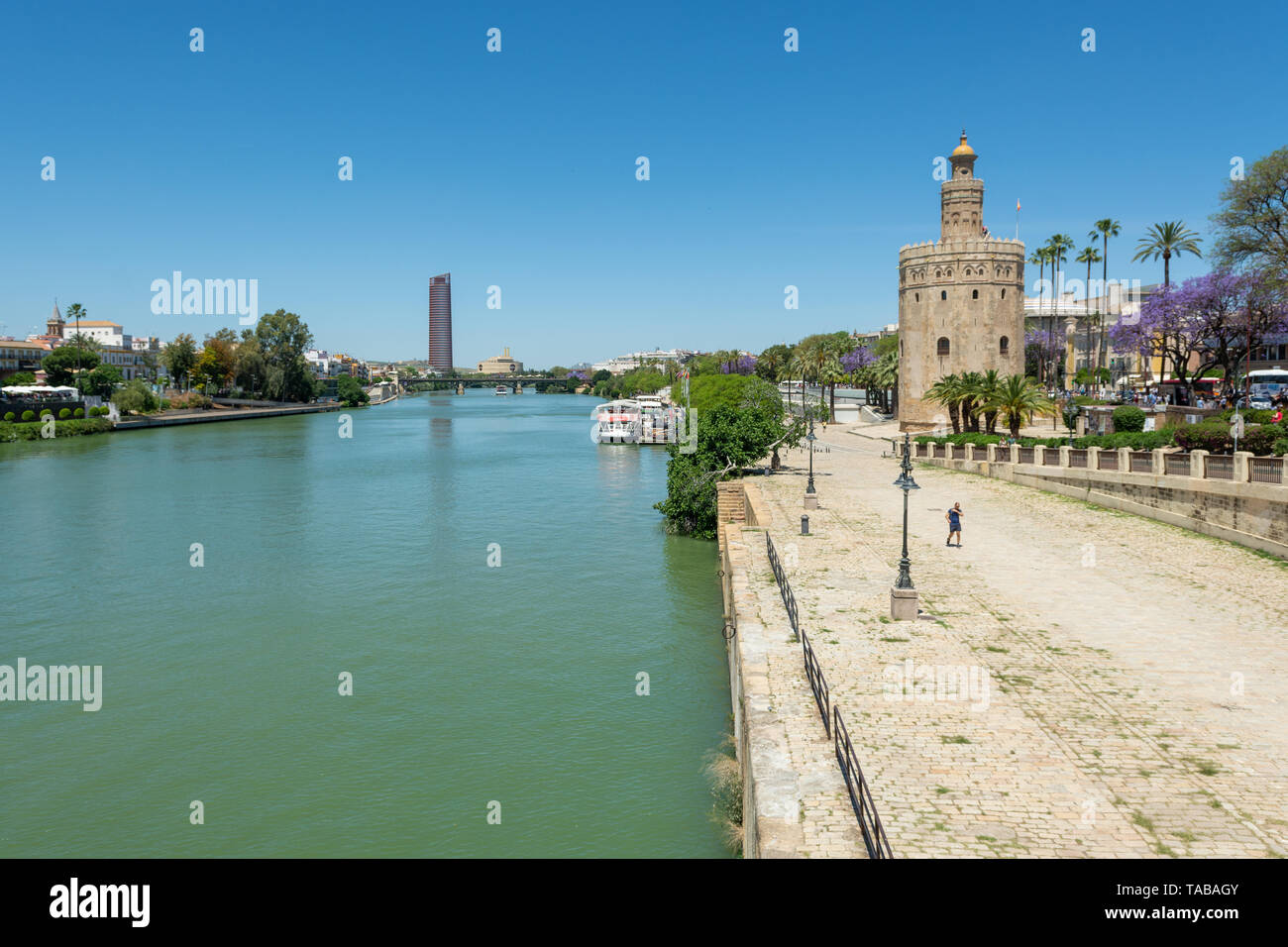 Torre del Oro Naval Museum Turm am Ufer des Canal de Alfonso XIII mit dem Torre Sevilla Turm in der Ferne, Sevilla, Region Andalusien, Spanien Stockfoto