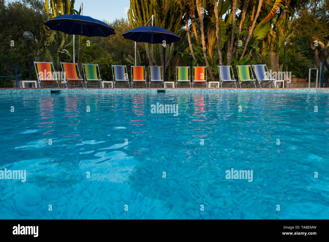 Bunte Liegestühle durch ein Pool, Capri, Italien. / Bunte Liegestühle am Pool, Capri, Italien. Stockfoto