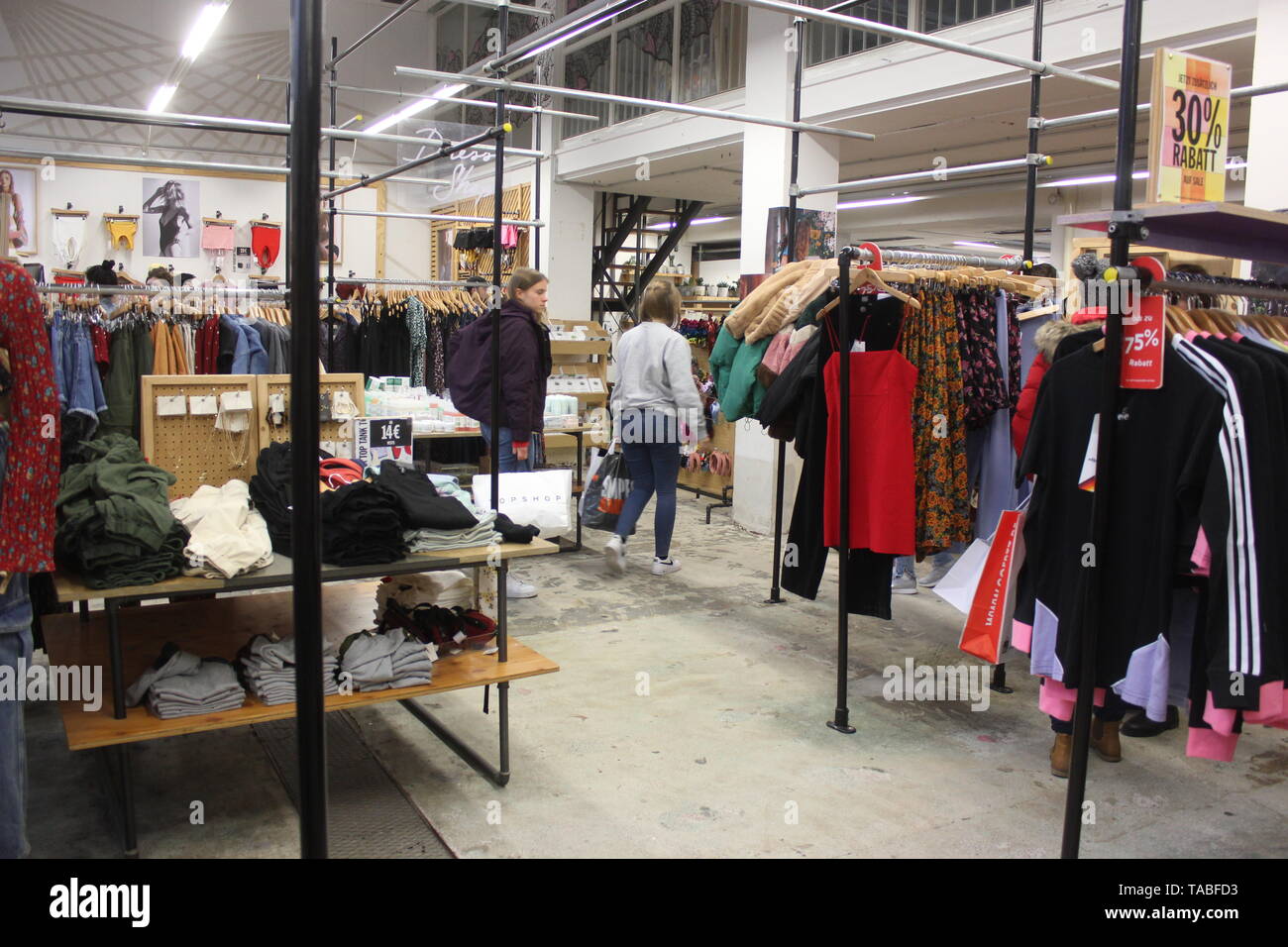 Innenraum der Pop-up Stores Urban Outfitters. Shop Interior mit textilen Produkten und cosumers eilt über die Prüfung von Preisnachlässen.. Stockfoto