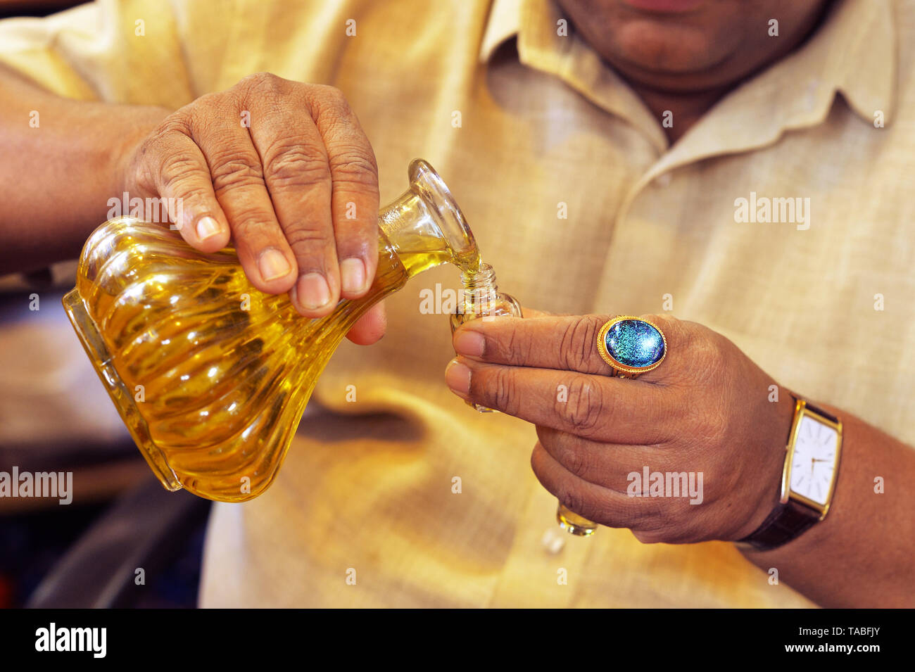 Man gießt ätherisches Öl aus Glas Flasche Nahaufnahme Stockfoto