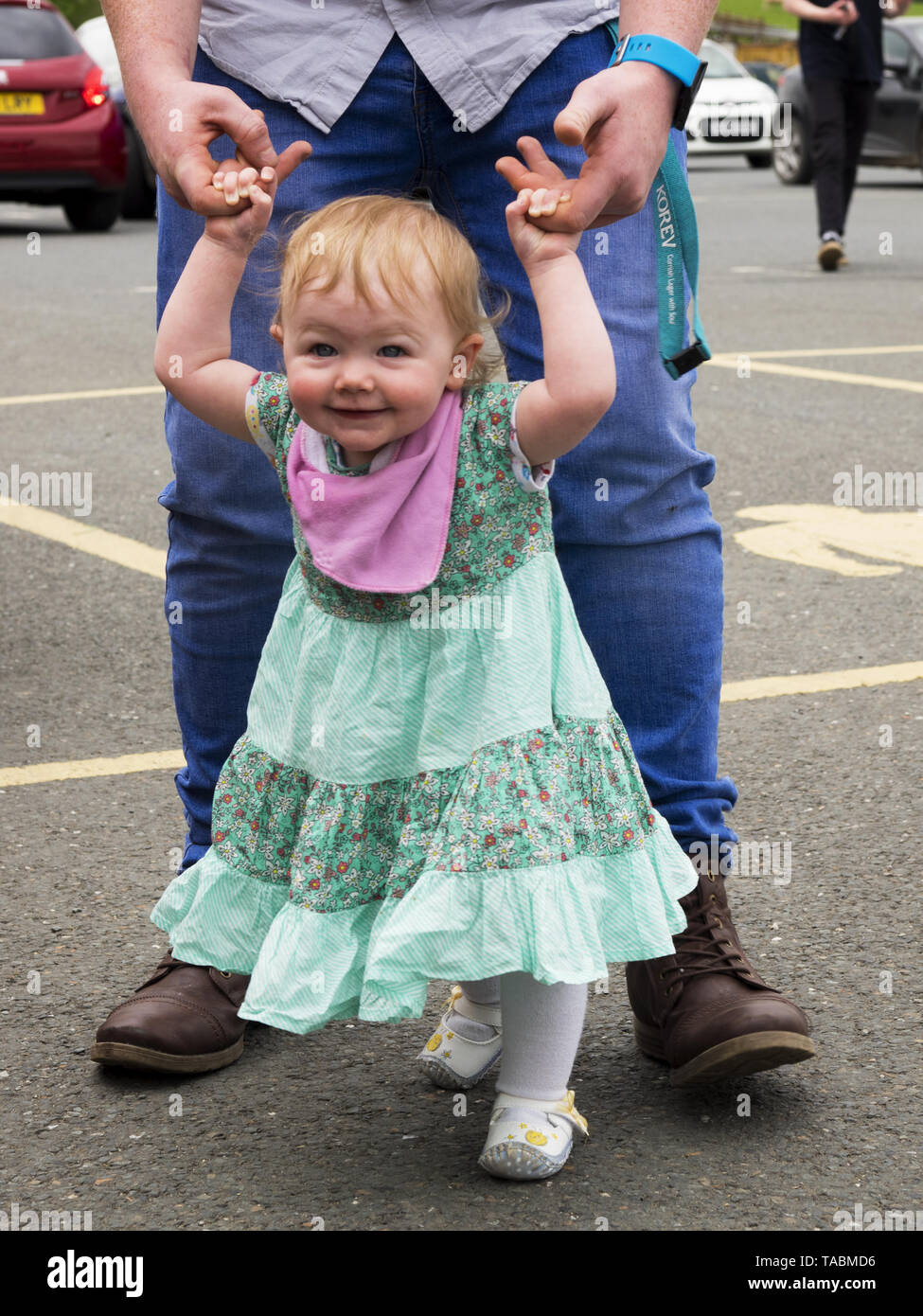 Ein Jahr alte kleine Mädchen lernen mit Hilfe von ihrem Vater zu gehen, Großbritannien Stockfoto