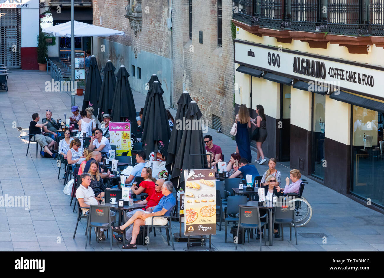 Kunden entspannen im außerhalb von Tabellen einer Coffee House in Sevilla Stockfoto