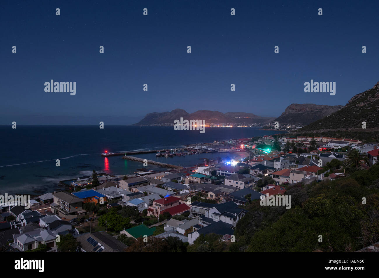 Nacht-, Mondschein Blick auf Kalk Bay und den Hafen bei Lastabwurf (geplant für Stromausfälle) in Kapstadt, Südafrika. Stockfoto
