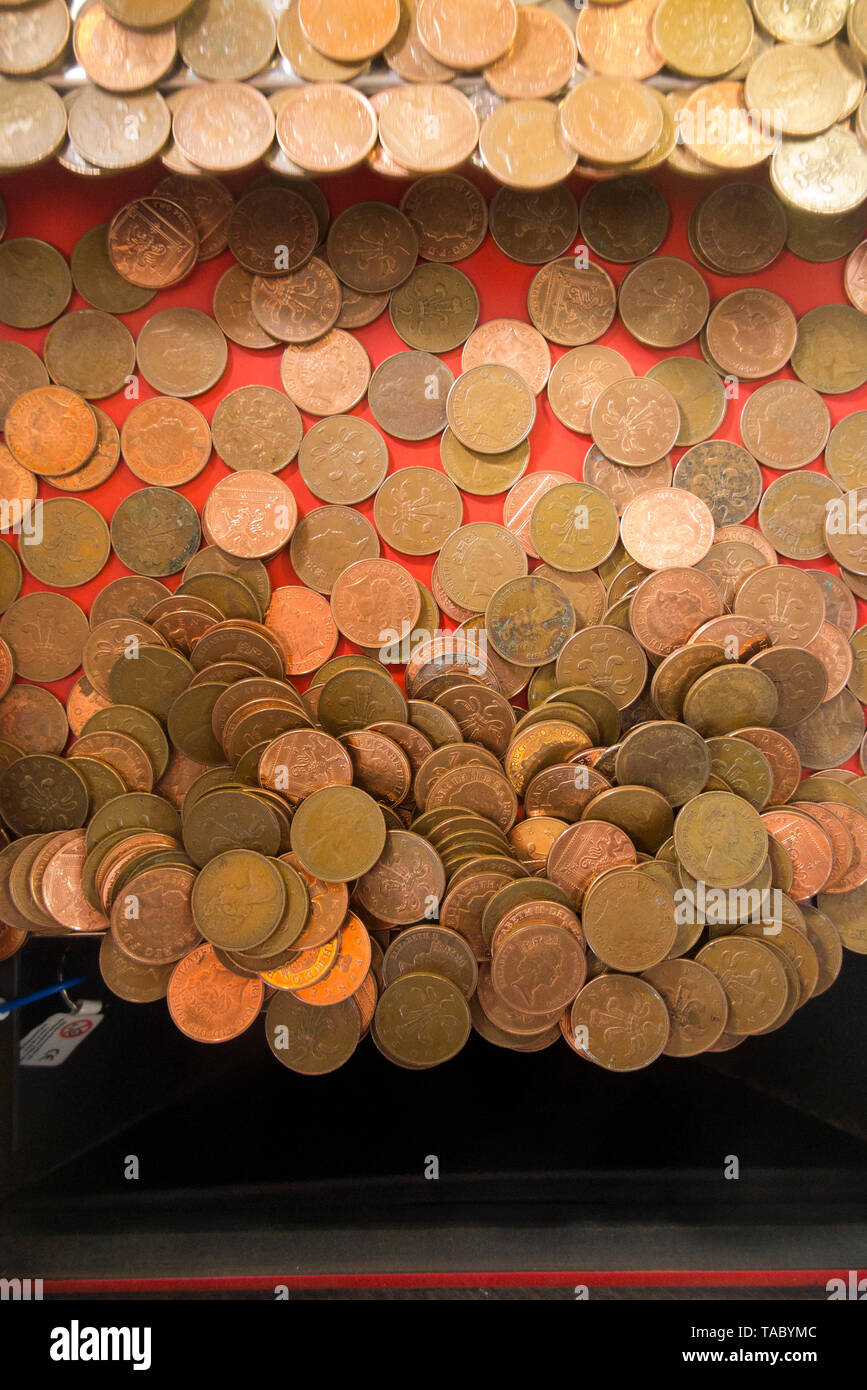 Zwei Pence 2 p Münzen warten zu fallen und (gewonnen oder verloren werden und an die Arcade Inhaber gehen) in einem traditionellen Coin Pusher/drücken, Münzen Spiel an einem (99 Stockfoto
