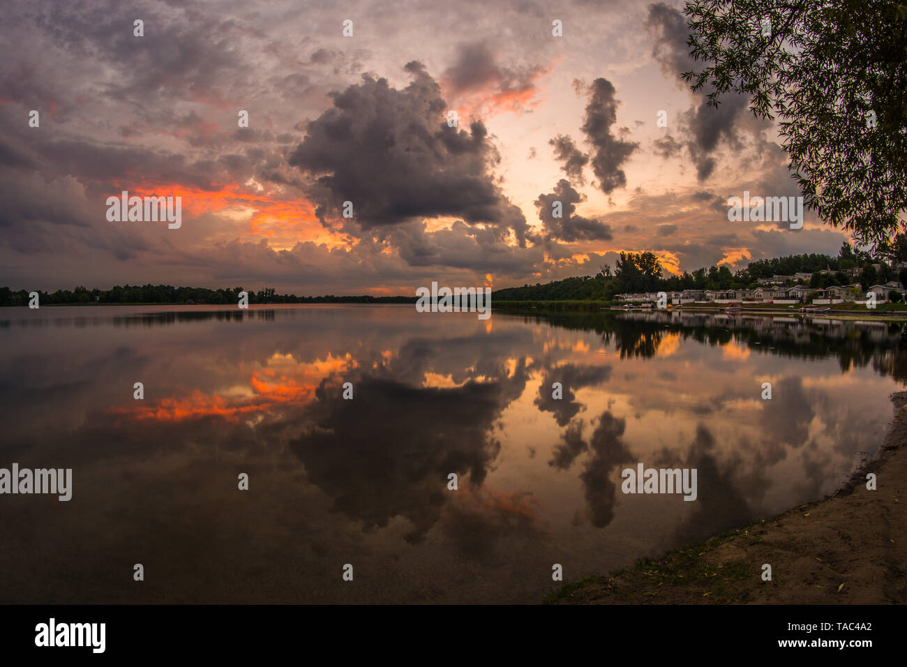 Ferienhaus See Szene, placid See bei Sonnenaufgang mit Cloud Reflexion auf See Wasser Stockfoto