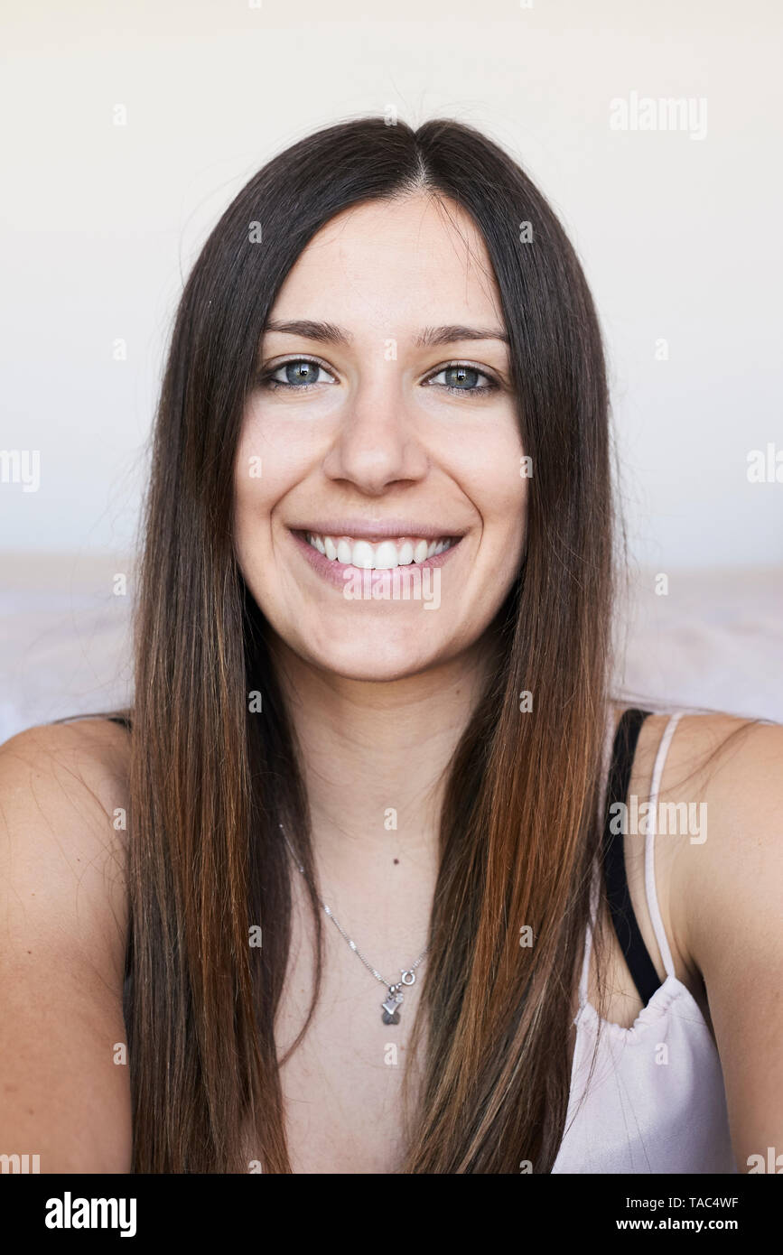 Porträt der glückliche junge Frau mit langen braunen Haaren Stockfoto