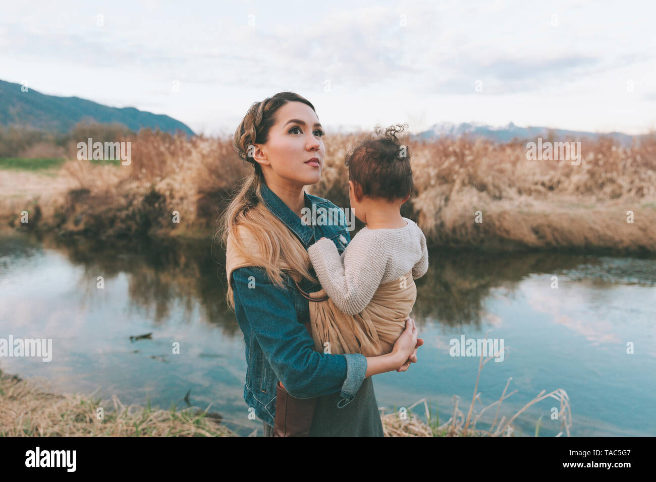 Die Mutter, die ihre kleine Tochter liebevoll in der Natur Stockfoto