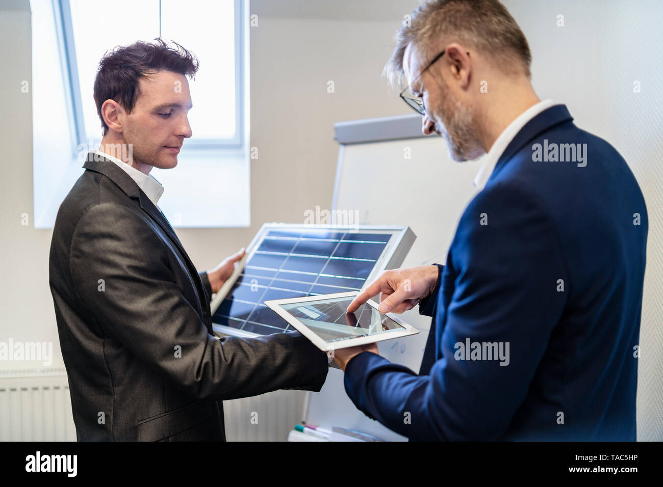 Zwei Geschäftsleute in Office mit Solarzelle und Tablet Stockfoto