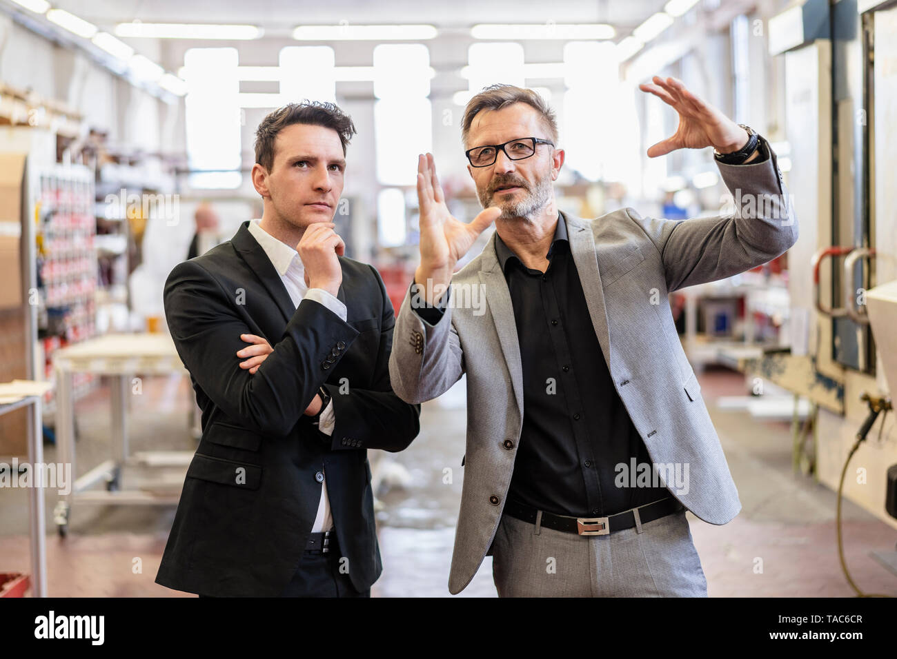 Zwei Geschäftsleute sprechen in einer Fabrik Stockfoto