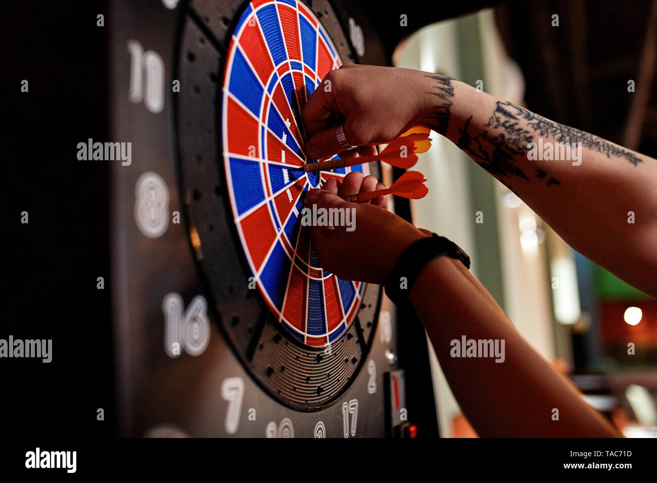 Nahaufnahme der tätowierten Mann, die Dart elektronische Dartscheibe Stockfoto