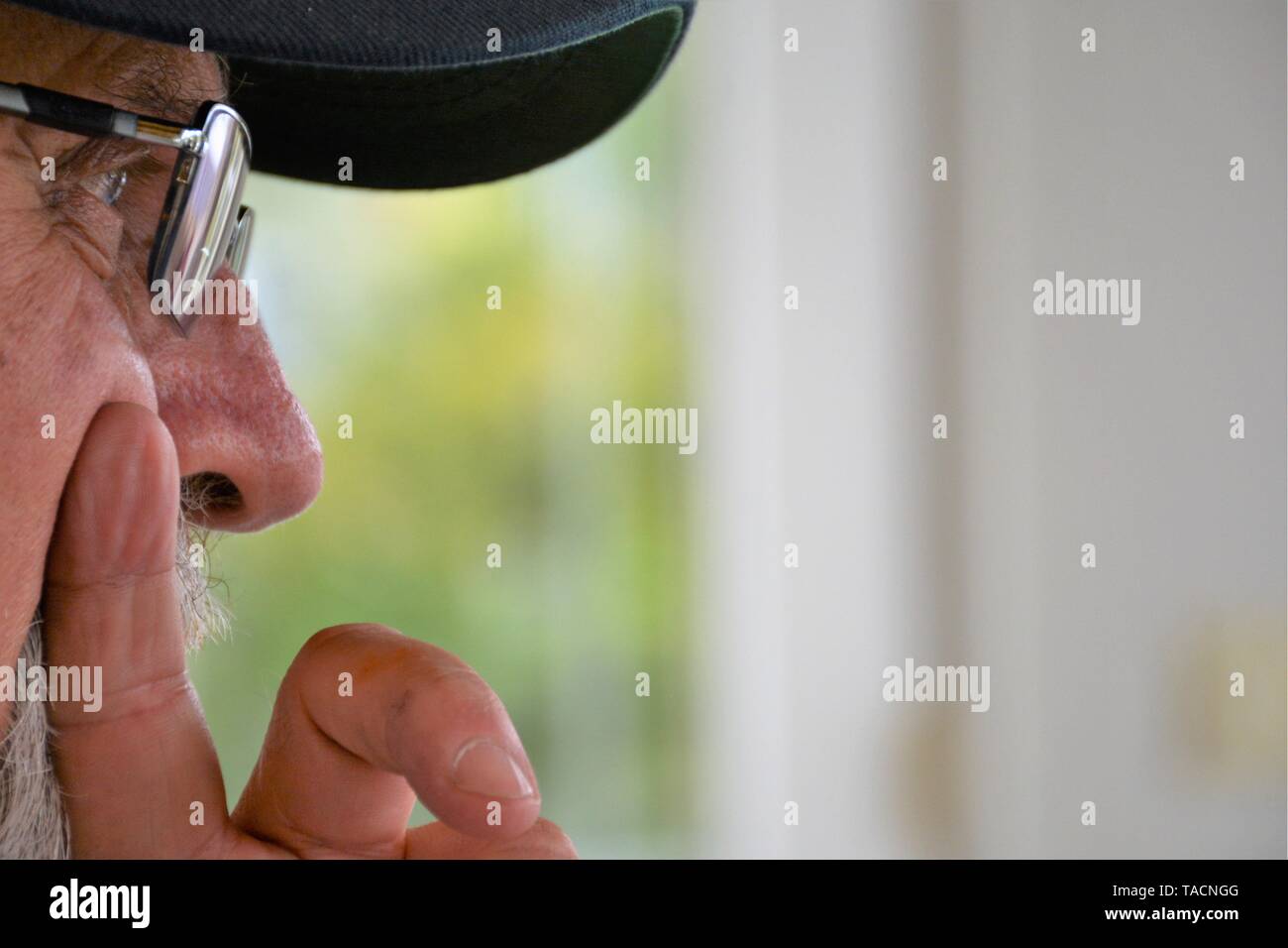 Älterer Mann, einen Punkt mit seinen Finger und Gespräch mit Freunden, mit Brille sehr Nahaufnahme Gesicht und Ball Cap Stockfoto